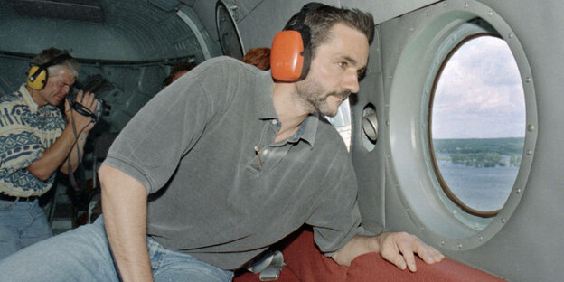 Aus einem Hubschrauber schaut ein Mann auf den Oderdeich im Oderbruch. Aus einem Hubschrauber schaut ein Mann auf den Oderdeich im Oderbruch.