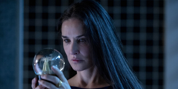 Düstere Stimmung, Demi Moore als Elisabeth Sparkle schaut in eine Glaskugel Düstere Stimmung, Demi Moore als Elisabeth Sparkle schaut in eine Glaskugel