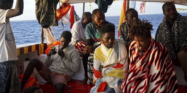 Mehrere Menschen warten auf einem Boot Mehrere Menschen warten auf einem Boot