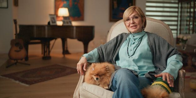 Googoosh sitzt in einem Ohrensessel, nebendran ihr kleiner Schoßhund Googoosh sitzt in einem Ohrensessel, nebendran ihr kleiner Schoßhund