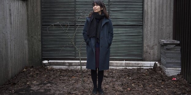 Han Kang steht in Winterkleidung auf abgefallenen Blättern Han Kang steht in Winterkleidung auf abgefallenen Blättern