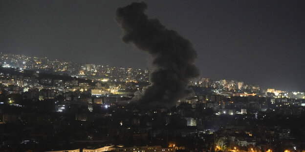 Rauchwolke über in der Nacht erleuchteter Stadt Rauchwolke über in der Nacht erleuchteter Stadt