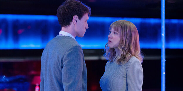 Louis Lewanski (George MacKay) und Gabrielle Monnier (Léa Seydoux) stehen sich steif vor einer neonbeleuchteten Kulisse gegenüber. Louis Lewanski (George MacKay) und Gabrielle Monnier (Léa Seydoux) stehen sich steif vor einer neonbeleuchteten Kulisse gegenüber.