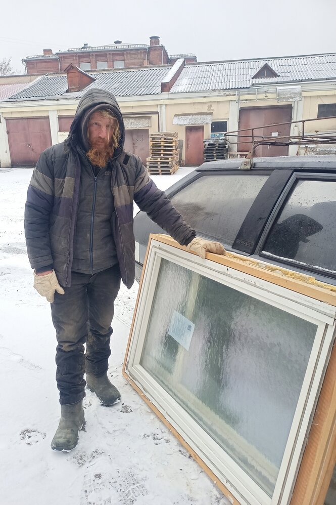 Ein Mann steht neben einem Auto, an das fensterscheiben gelehnt sind