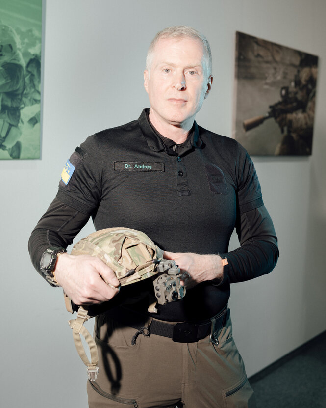 Porträt von Björn Andres mit einem Helm unterm Arm.