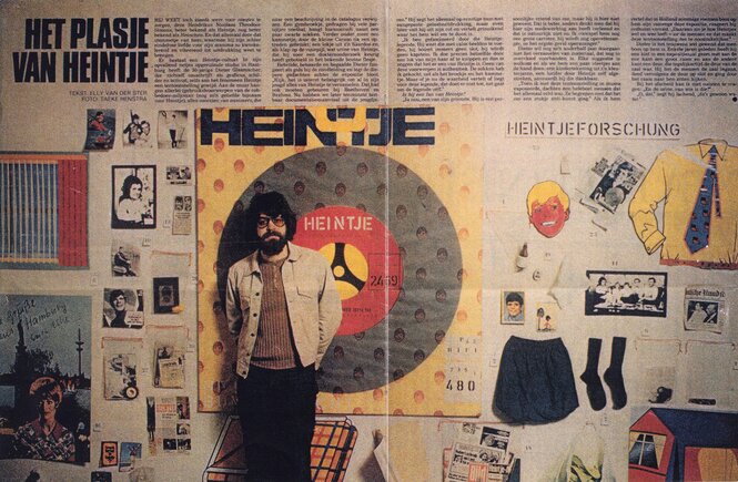 Früher Illustrierter Zeitungsbeitrag über die Heintje-Forschung: Das Foto zeigt Dieter Glasmacher, ein damals knapp 30 Jahre junger Man mit vollem Lockenkopf, Bart und Brille, steht vor einer Wand mit Heintje-Devotionalien
