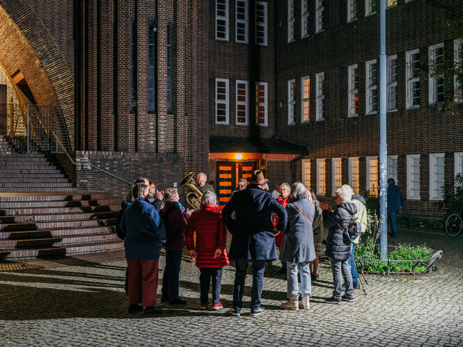 Eine Gruppe von älteren Menschen steht vor einer Kirche