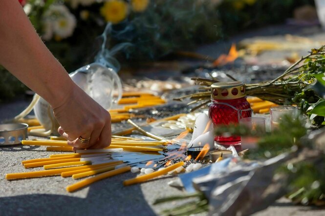 Menschen zünden Kerzen zum Gedenken an