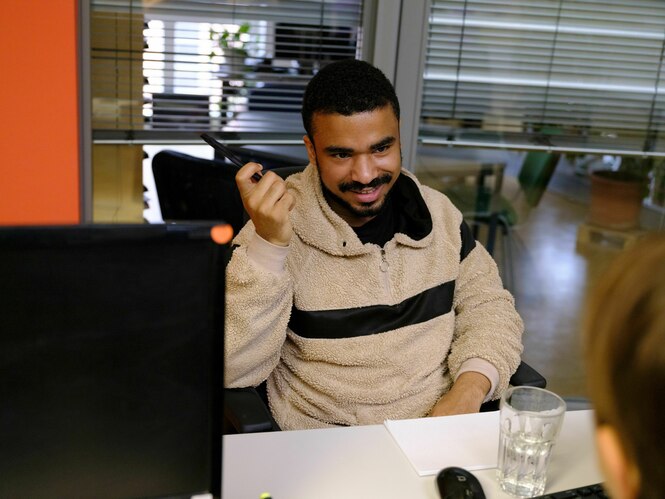 Ein Berater im Gespräch sitzt an einem Schreibtisch